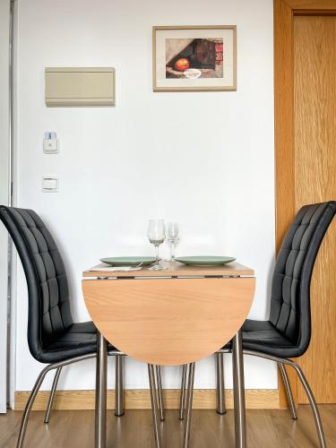 a table with black chairs and a table with wine glasses at Beatriz Charming Hostal in Torremolinos
