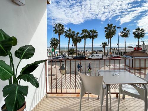 a balcony with a table and a view of a beach at Beatriz Charming Hostal in Torremolinos