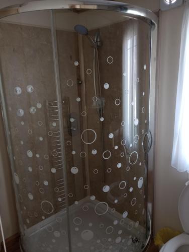 a shower with a glass door in a bathroom at Luxury 2 bedroom caravan with large decking Close to beach in Abergele