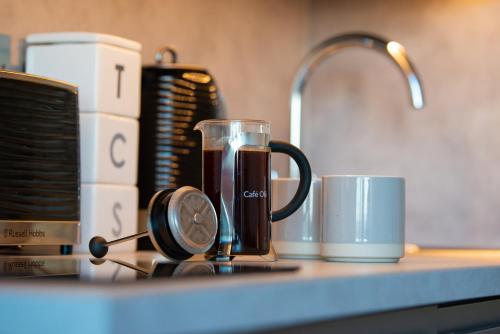 a cup of coffee sitting on a counter next to a mug at Bonnie Barns - Adults Only Luxury Lodges with hot tubs in Luss