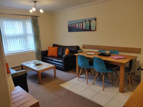 a living room with a table and a couch at Hartford Court, East Cliff, Bournemouth. Walk to beach and town in Bournemouth