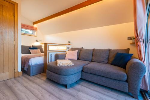 a living room with a couch and a bed at Bonnie Barns - Adults Only Luxury Lodges with hot tubs in Luss
