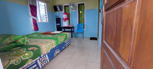 a bedroom with a bed and a table and a door at Villa Dono in Pasuruan