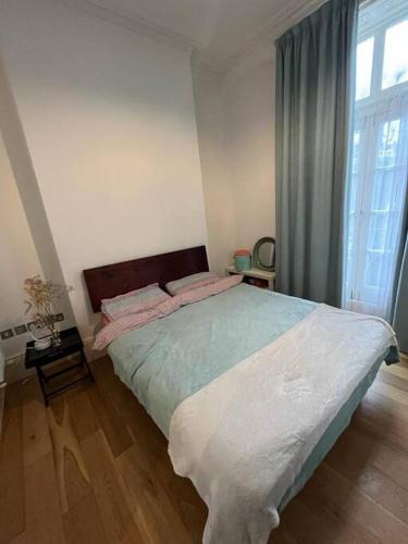 sypialnia z dużym łóżkiem i dużym oknem w obiekcie Amazing Central London Apartment w Londynie