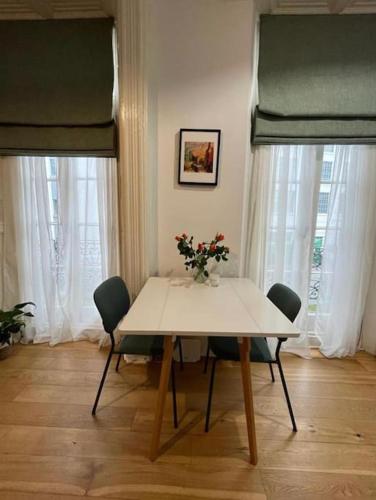 stół jadalny z krzesłami i wazon kwiatów w obiekcie Amazing Central London Apartment w Londynie