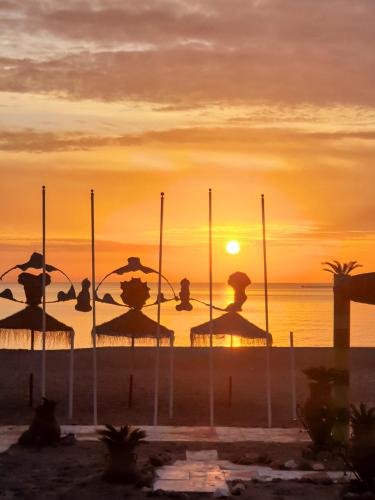 a group of umbrellas on the beach at sunset at Beatriz Charming Hostal in Torremolinos