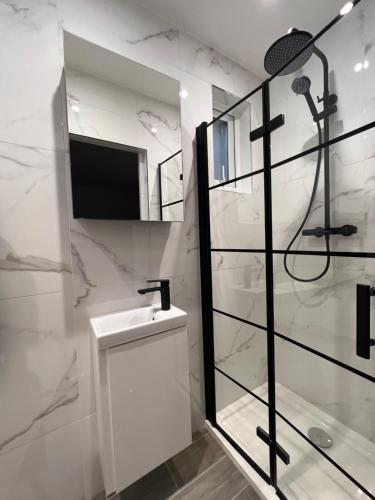 a white bathroom with a sink and a shower at Star London Finchley Lane 2-Bed Oasis with Garden in Hendon