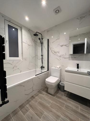 een badkamer met een toilet, een douche en een wastafel bij Star London Finchley Lane 2-Bed Oasis with Garden in Hendon