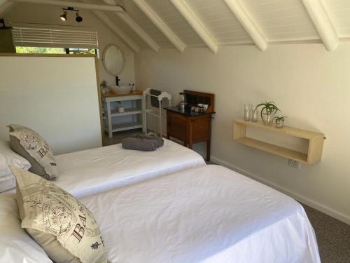 a room with two beds and a table with a mirror at 47 on the Run in St Francis Bay