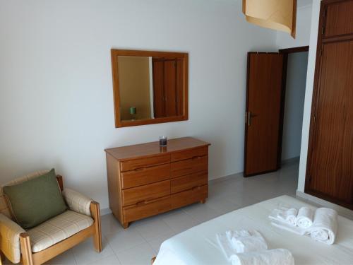 een slaapkamer met een bed, een stoel en een dressoir bij COZY APARTMENT IN LAGOS in Lagos
