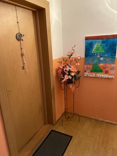 a door with a vase of flowers next to a painting at Schöne Ferienwohnung in Bahnhofsnähe für Urlaub, Studium oder Arbeit in Deggendorf