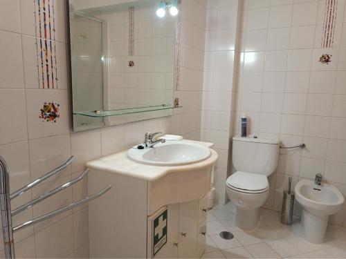 een badkamer met een wastafel, een toilet en een spiegel bij COZY APARTMENT IN LAGOS in Lagos