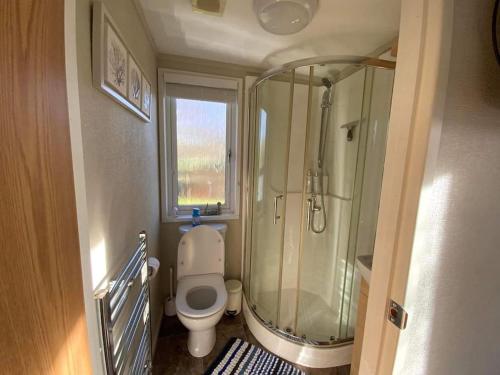 a small bathroom with a shower and a toilet at Honeybee Lodge in Wisbech