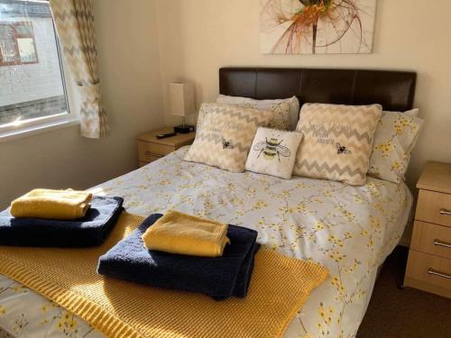 a bedroom with a bed with two towels on it at Honeybee Lodge in Wisbech