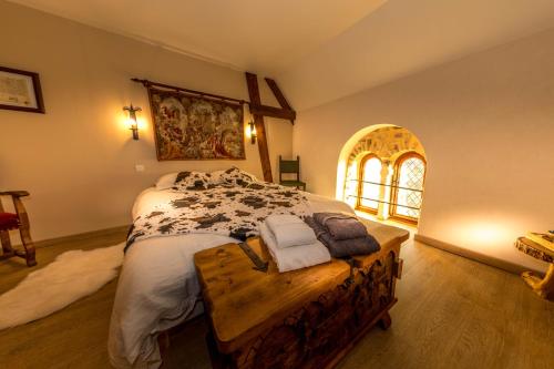 Un dormitorio con una cama y una mesa con toallas. en Domaine de la Ferté Clairbois en Sainte-Suzanne