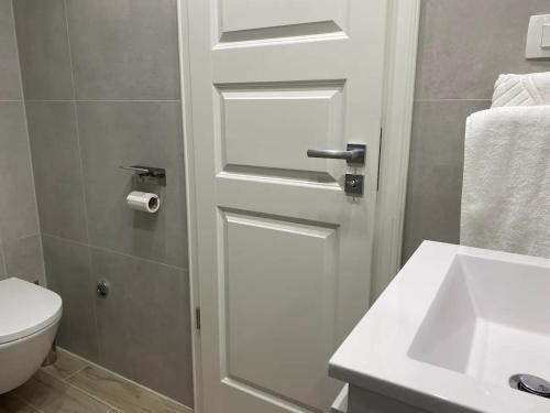 a bathroom with a white door and a sink at Cloe Apartment in Split