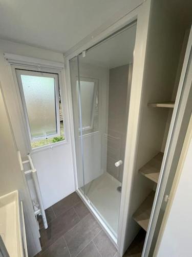 une salle de bain avec une douche en verre avec une fenêtre dans l'établissement Vue sur le lac, cadre verdoyant, camping 4 étoiles, à Aureilhan
