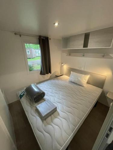 - une petite chambre avec un grand lit blanc et une fenêtre dans l'établissement Vue sur le lac, cadre verdoyant, camping 4 étoiles, à Aureilhan