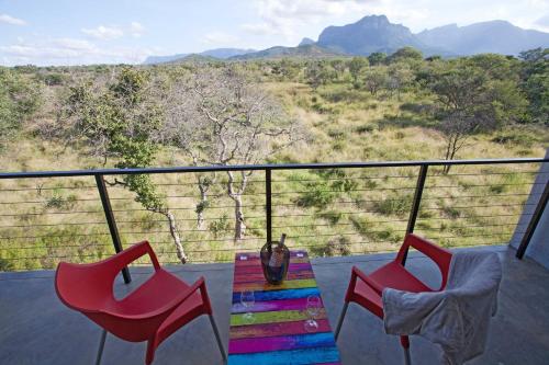 a balcony with two chairs and a table with a view at Kruger Cliffs Lodge - Absolute privacy guaranteed in Hoedspruit