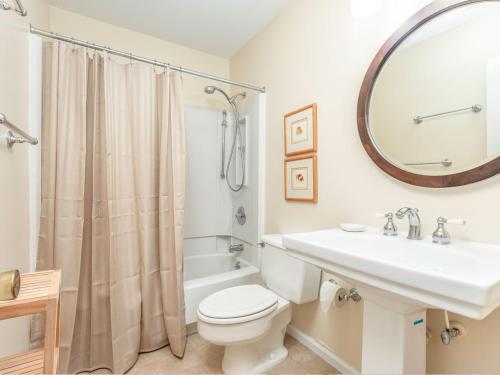 a bathroom with a sink and a toilet and a mirror at Lighthouse Point 4B in Tybee Island