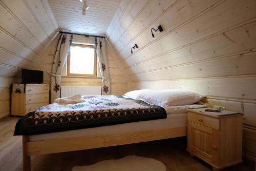 a bedroom with a bed in a tiny house at Domeczek Góralski Zakopane in Zakopane