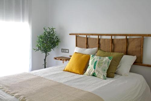 - une chambre avec un lit et des oreillers dans l'établissement Home of the Sun - Luminoso adosado con vistas al mar y a 2 km de la playa, à Vélez-Málaga