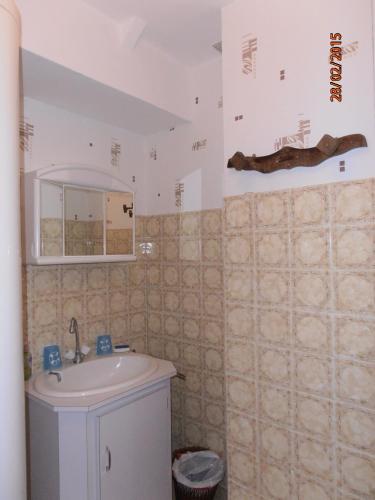 une salle de bain avec un lavabo et un miroir dans l'établissement Les Galets, à Tracy-sur-Mer