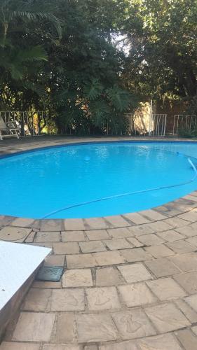 a large blue swimming pool in a yard at Luxury Upmarket Guesthouse 20 on 4th in Rustenburg