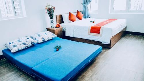 a bedroom with two beds and a blue bed sidx sidx sidx at Delicate Serviced Apartment And Hotel in Da Nang