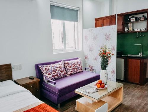 a living room with a purple couch and a table at Delicate Serviced Apartment And Hotel in Da Nang