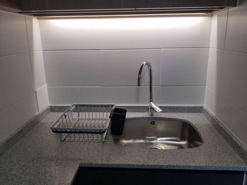 a kitchen sink with a faucet and a shelf at Hermoso departamento completamente equipado in Osorno