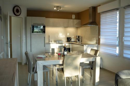 une cuisine avec une table et des chaises dans une cuisine dans l'établissement Bel appartement à 50m du port de plaisance, à Saint-Valery-sur-Somme