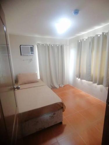 a small room with a bed and a tv at Furnished 2Br Condo With Balcony in Cagayan de Oro