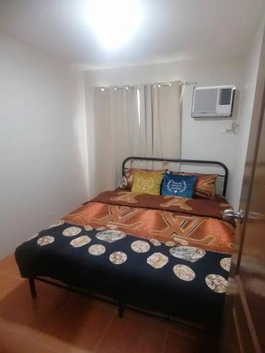 a small bedroom with a bed in a room at Furnished 2Br Condo With Balcony in Cagayan de Oro