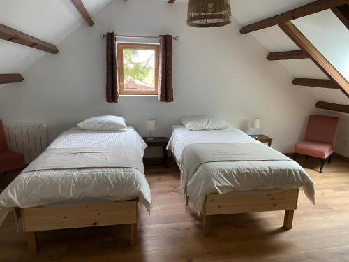 two twin beds in a room with a window at Les Galets 1 in Auchonvillers