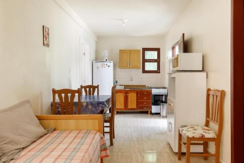 a small kitchen with a table and a refrigerator at Pousada Residencial Bambus in Florianópolis