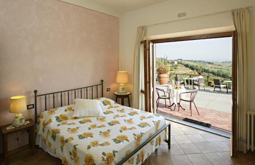a hotel room with a bed, chair, and table at B&B I Coppi in San Gimignano