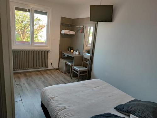 a bedroom with a bed and a desk and a window at le saint firmin in Le Crotoy