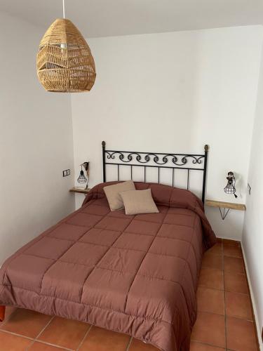 ein Schlafzimmer mit einem Bett mit einer braunen Decke in der Unterkunft Congrio10, Las Negras in Las Negras