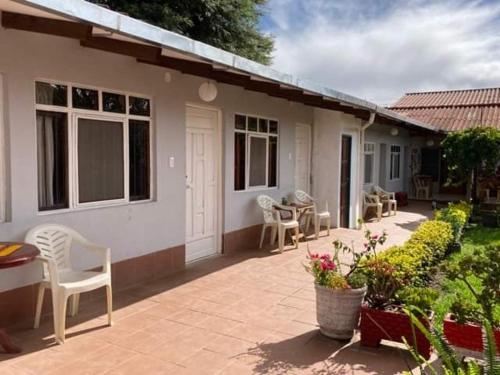 eine Terrasse eines Hauses mit Stühlen und einem Tisch in der Unterkunft Casa Sayana in Samaipata