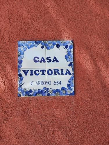 a sign on the side of a red wall at Casa Victoria in Colonia del Sacramento