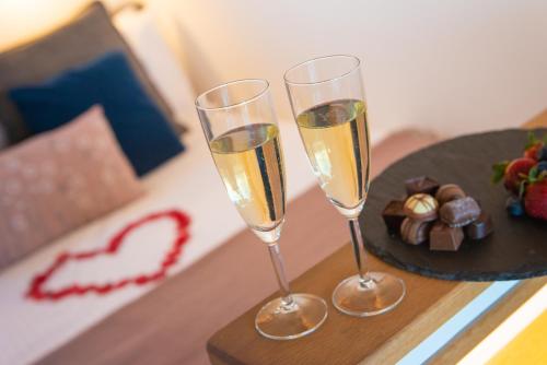 two glasses of champagne on a table with a plate of chocolate at Bonnie Barns - Adults Only Luxury Lodges with hot tubs in Luss