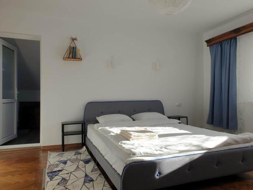 un letto in una camera da letto con tenda blu di Guest House La TaTa a Gura Haitii