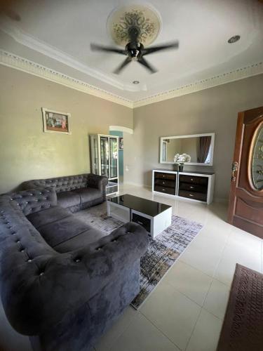 - un salon avec un canapé et un ventilateur de plafond dans l'établissement DnD Homestay, à Kuala Terengganu