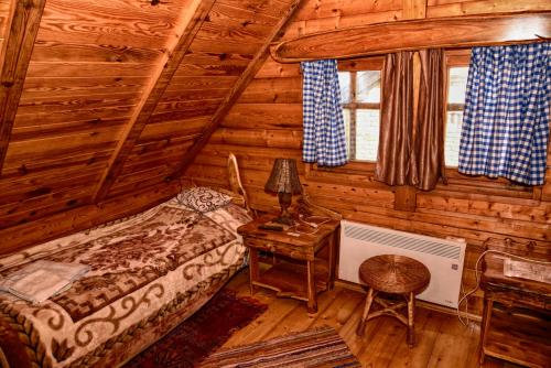 a bedroom with a bed in a log cabin at Guesthouse Peto in Novi Kneževac