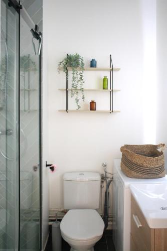 a bathroom with a toilet and a glass shower at Studio neuf Paris - La Défense in Colombes