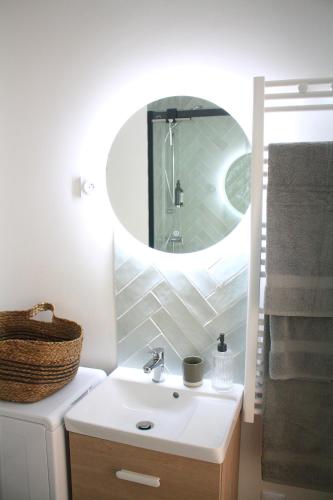 a bathroom with a sink and a mirror at Studio neuf Paris - La Défense in Colombes