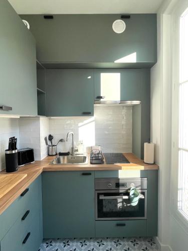 a kitchen with a sink and a stove at Studio neuf Paris - La Défense in Colombes