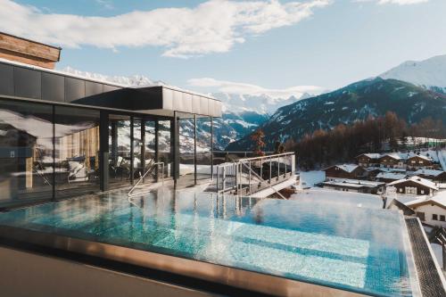 a swimming pool on top of a building with mountains at Alpine Resort Goies Superior in Ladis