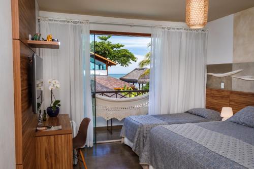 1 dormitorio con 2 camas y vistas al océano en Pousada Rigatoni, en Arraial d'Ajuda